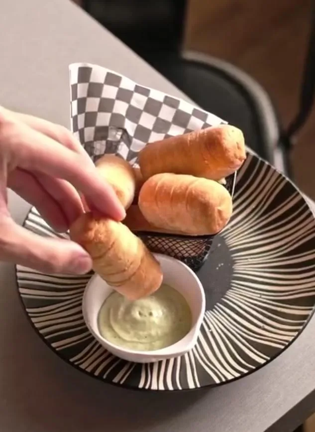 Tequeños Glück recién hechos servidos en cesta con salsa de ajo en un restaurante